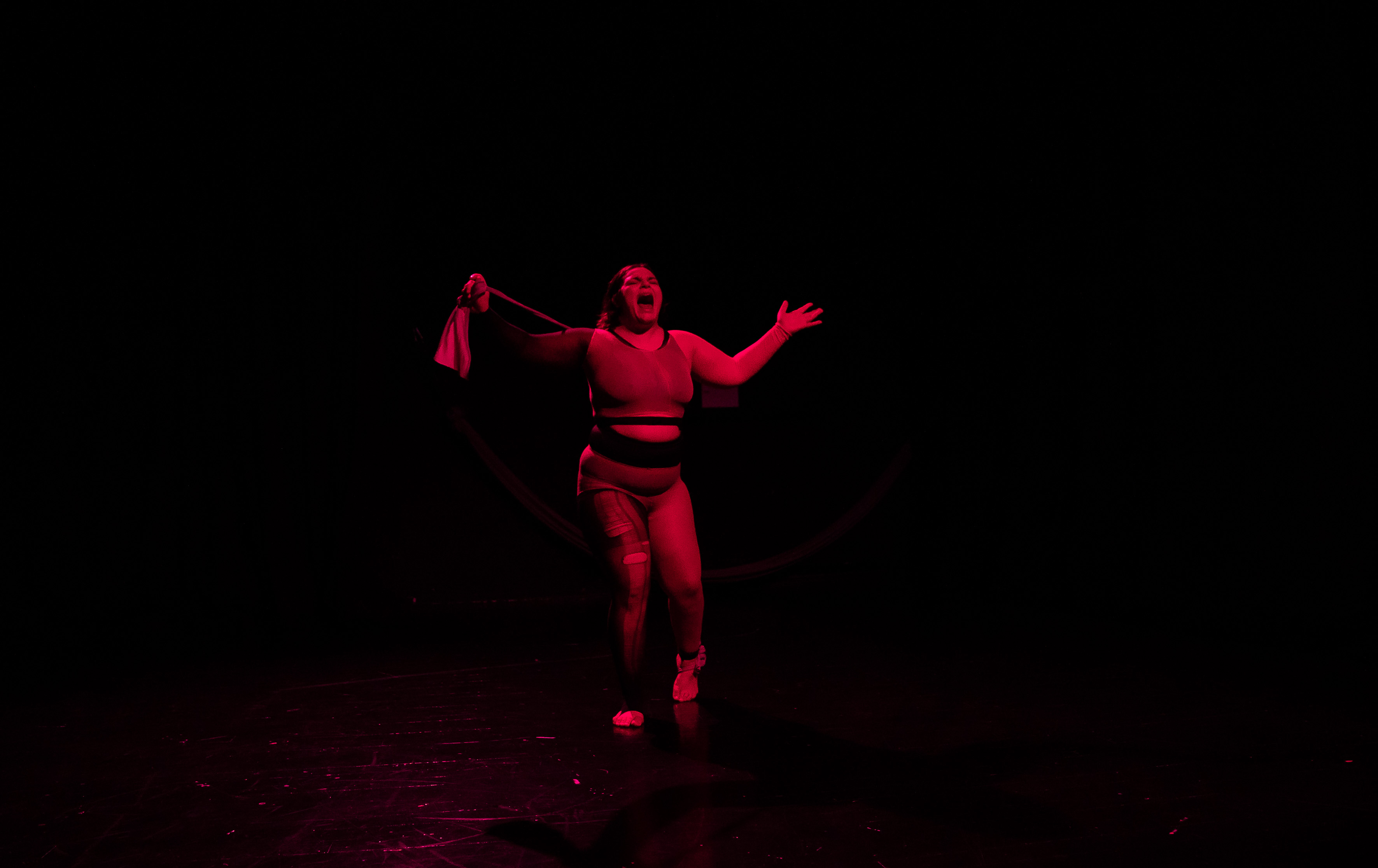 Linnea Sundblom i scenljus, skrikandes med utsträckta armar.